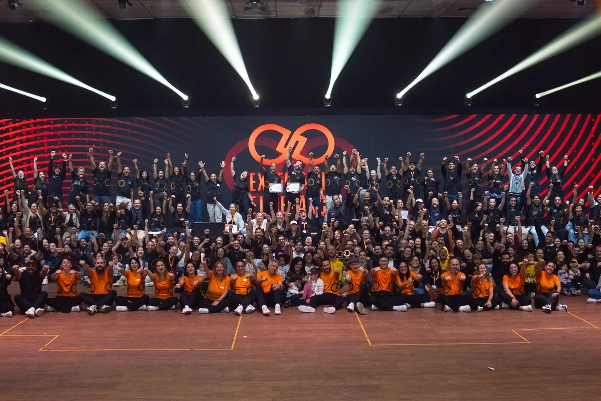 Participantes reunidos no palco de um evento do ELOS